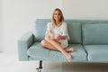 portrait of a young charming woman in a silk robe with cup of coffee at home on the sofa Royalty Free Stock Photo