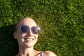 Portrait young adult bald shaved beautiful caucasian woman enjoy having fun lying on green grass lawn and smiling Royalty Free Stock Photo