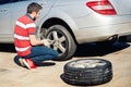 Portrait of young adult changing tyres and enjoying a sunny day