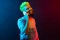 Portrait of young adult hipster man wearing denim overalls and t shirt talking phone, hears happy news, smiles toothily, Royalty Free Stock Photo