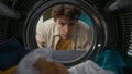 View from inside the washing machine, adult man looking inside the washer drum Royalty Free Stock Photo