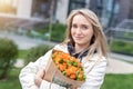 Portrait young adult smiling classy woman model hand holding authentic fresh orange spray roses flower bouquet wrapped in craft Royalty Free Stock Photo