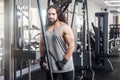 Portrait of young adult sport athlete man with long curly hair training at gym alone, standing and lifting weights in the gym, Royalty Free Stock Photo