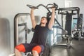 Portrait of young adult sport athlete man training at gym alone and lifting weights while sitting on the bench in the gym Royalty Free Stock Photo