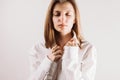 Portrait of young adult woman with eyes closed holding collar of white shirt with her hands Royalty Free Stock Photo