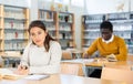 Young adult woman studying in public library Royalty Free Stock Photo