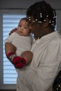 Portrait of young african american black father holding mulatto baby with christmas themed socks. Multiracial family