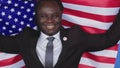 Portrait, young african american black man in formalwear with usa badge on the chest holding usa flag