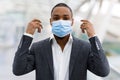 Portrait Of Young African American Businessman Taking Off Medical Face Mask Royalty Free Stock Photo
