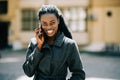 Portrait of young african american girl talking by mobile phone, smiling. Sunny day. Outdoor photo Royalty Free Stock Photo