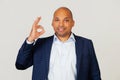 Portrait of a young African American guy businessman, smiling positively, making okay sign with hand and fingers. Lucky expression Royalty Free Stock Photo