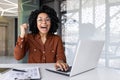 Portrait of a young African American Inca woman working in the office using a laptop, happy and celebrating success to Royalty Free Stock Photo