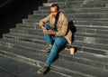 Portrait of young african american man sitting on steps using mobile Royalty Free Stock Photo