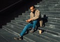 Portrait of young african american man sitting on steps using mobile Royalty Free Stock Photo