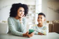 Portrait of young african american mother hold smartphone reading teaching little boy in living room. Royalty Free Stock Photo