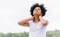 Portrait of young african american woman having rest outdoors in the park, with hands on raised head, looking up, feel free. Royalty Free Stock Photo