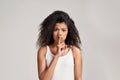 Portrait of young african american woman making silent gesture, holding finger on her lips while standing isolated over Royalty Free Stock Photo