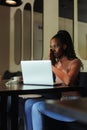 Portrait of young African-American woman sitting at table near laptop, showing thank you, folding hands at screen. Royalty Free Stock Photo