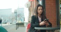 Portrait of young African American woman using phone, outdoors. Royalty Free Stock Photo