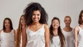 Portrait of young african american woman in white shirt smiling at camera. Group of diverse women standing isolated over Royalty Free Stock Photo