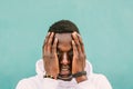 Portrait of young african black man against a green wall with white sweatshirt with his hands on his face. Stop racism protest Royalty Free Stock Photo