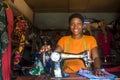 Portrait of a young african female tailor smiling while working with her sewing machine.