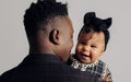 Portrait of young african man holding on arms his baby daughter from interracial marriage