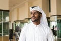 Portrait of African Muslim man wearing religious clothing an scarf at office while thinking Royalty Free Stock Photo