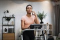 Portrait of young african sportive woman in sportswear talking on smartphone while training at home Royalty Free Stock Photo