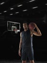 Portrait of young African sportsman, basketball player posing in gym, idoors isolated on dark background. Concept of Royalty Free Stock Photo