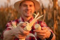 Young farmer standing in corn field, examining the crop before harvest at sunset. Royalty Free Stock Photo