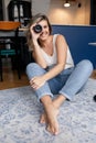 Portrait of young amazing woman photographer sitting with crossed legs, holding, looking through modern camera lens. Royalty Free Stock Photo