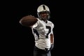 Portrait young American football player, athlete in black white sports uniform posing  on dark studio background Royalty Free Stock Photo