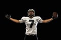 Portrait young American football player, athlete in black white sports uniform training isolated on dark studio Royalty Free Stock Photo