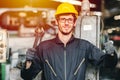 Portrait of young American happy worker enjoy happy smiling to work in a heavy industrial factory.Thumb up with big wrench