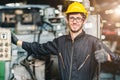 Portrait of young American happy worker enjoy happy smiling to work in a heavy industrial factory.Thumb up with machine controller