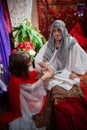 Portrait of young arabian muslim couple in traditional clothes in cozy red room. Fhoto shoot in easten style with male