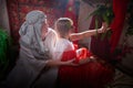 Portrait of young arabian muslim couple in traditional clothes in cozy red room. Fhoto shoot in easten style with male