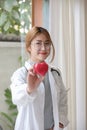 Portrait young asian beautiful doctor with stethoscope holding heart while standing at her office. Royalty Free Stock Photo