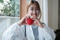 Portrait young asian beautiful doctor with stethoscope holding heart while standing at her office. Royalty Free Stock Photo