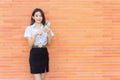 Portrait young Asian beautiful and pretty Thai girl student in uniform while using smartphone she happy confident smile and Royalty Free Stock Photo