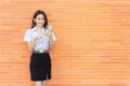 Portrait young Asian beautiful and pretty Thai girl student in uniform while using smartphone she happy confident smile and Royalty Free Stock Photo