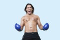 Portrait of young Asian boxer screaming over blue background