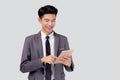 Portrait young asian business man in suit standing using tablet computer to internet isolated on white background. Royalty Free Stock Photo