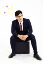 Portrait of young Asian businessman with Glasses and briefcase. Successful business man wearing suit sitting on briefcase white Royalty Free Stock Photo