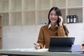 Portrait young asian businesswoman beautiful charming smiling and talking on the mobile phone in the office. Royalty Free Stock Photo