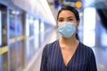 Young Asian businesswoman with mask for protection from corona virus outbreak waiting at the subway train station Royalty Free Stock Photo