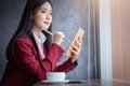 Portrait of Young asian businesswoman sitting indoors in cafe using digital tablet with coffee. Business success concept Royalty Free Stock Photo