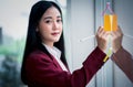 Portrait of Young asian businesswoman writing sticky paper pad on glass in modern office. Business plan concept Royalty Free Stock Photo