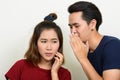 Portrait of young Asian couple whispering together Royalty Free Stock Photo